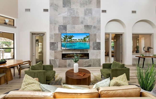 a living room with couches and chairs and a tv on the wall