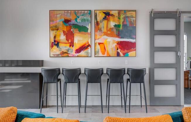 a dining room with chairs and paintings on the wall  at Affinity 56 Apartments in West Jordan, Utah