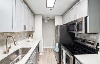 a kitchen with stainless steel appliances and white cabinets at View at Lake Lynn, Raleigh