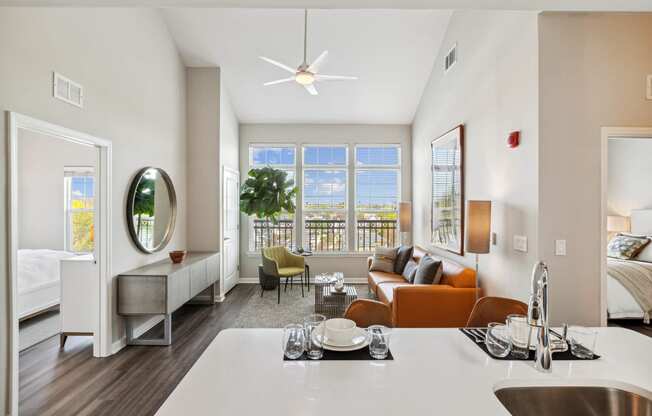 a living room with white walls and a large window with a view of a body of water at Metro 303, Hempstead