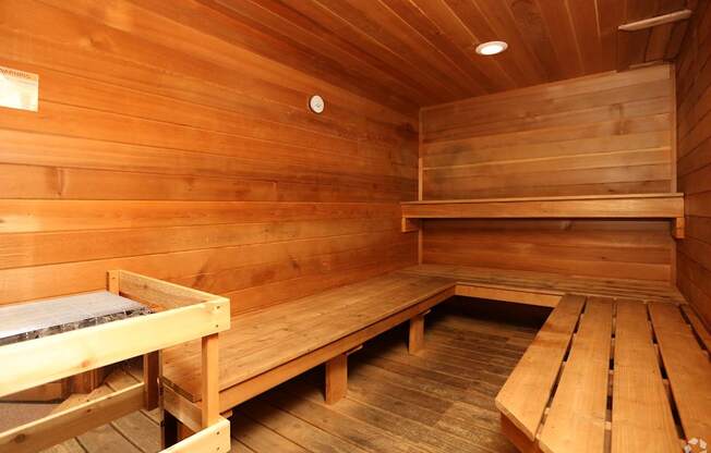 A wooden sauna with benches and a heater.