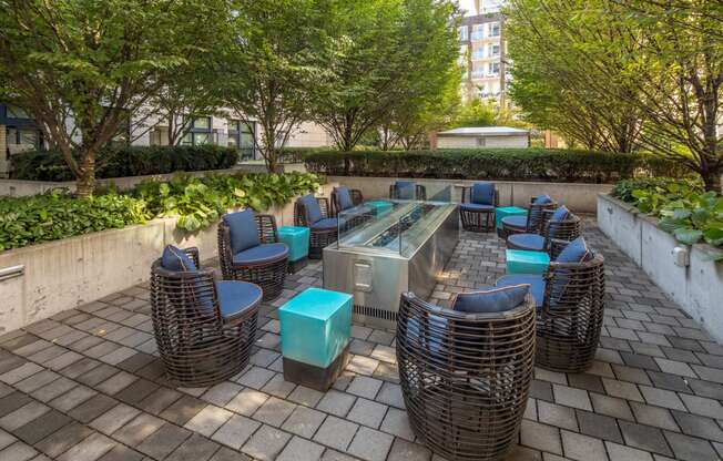 a seating area with wicker chairs and blue tables on a brick patio at The Parker, Oregon, 97209