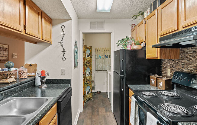 a kitchen with black appliances and wood cabinets