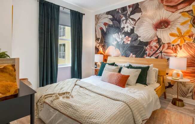 Model bedroom with a bed and a mural on the wall