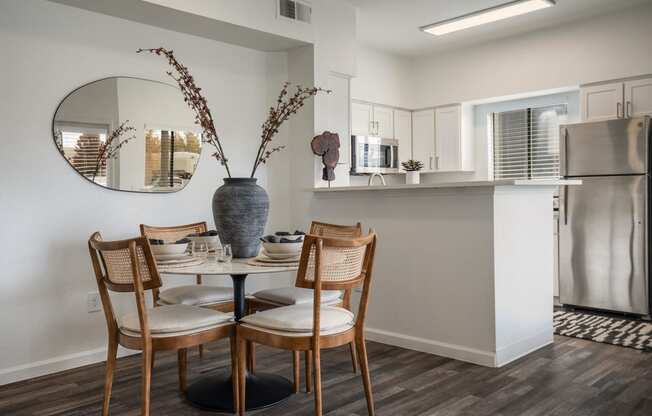 a dining room with a table and chairs and a kitchen with a refrigerator