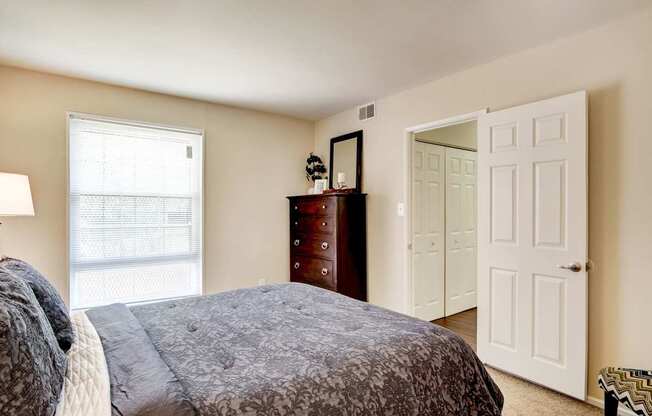 A bedroom with a bed, dresser, and mirror.