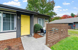 Apartment exterior with a yellow door and patio