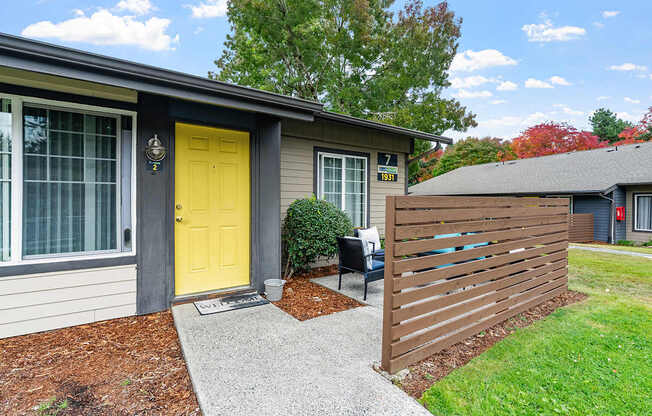 Apartment exterior with a yellow door and patio