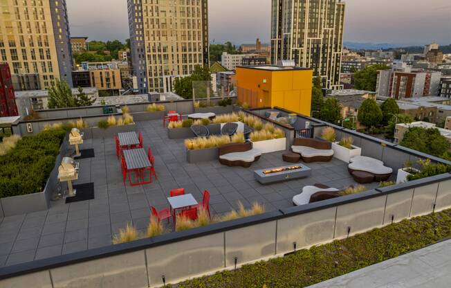 a roof deck with lounge furniture and a yellow building in the background