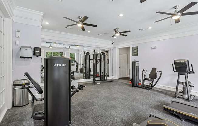 A gym with a variety of equipment including a treadmill, weights, and a bench press.