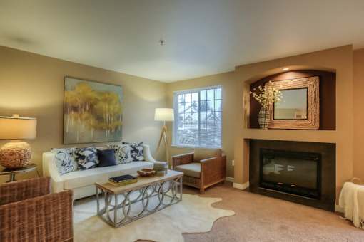 A living room with a fireplace and a painting on the wall.