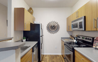 a kitchen with a black refrigerator freezer next to a stove top oven