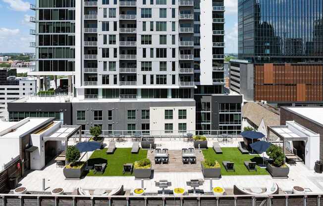 A modern building with a rooftop garden and seating area.