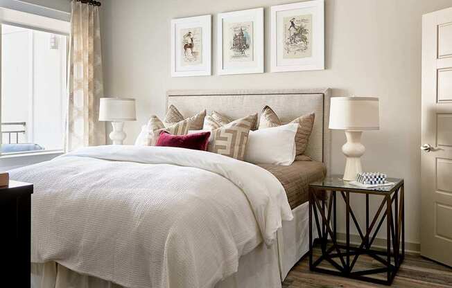 A bedroom with a large bed and a window with curtains.