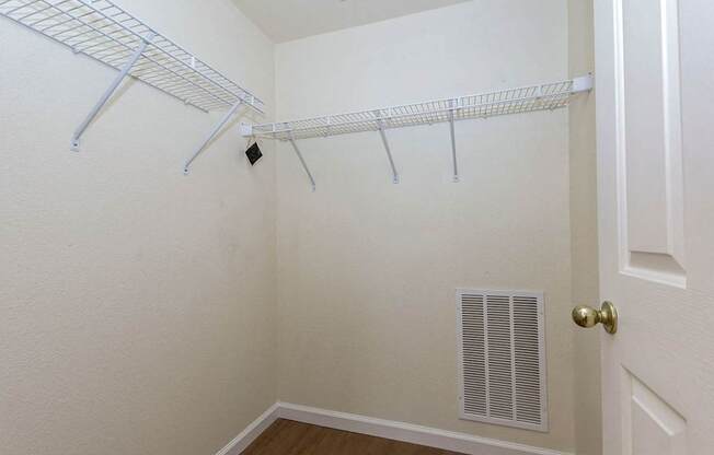 A white closet with a door and a vent.