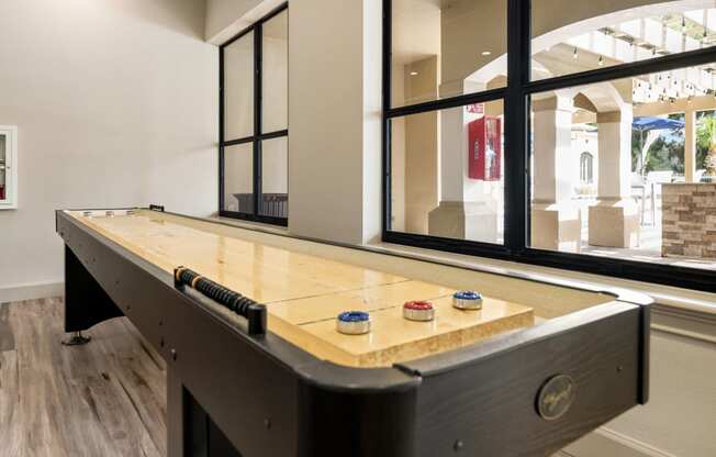 a billiards table in a game room with windows