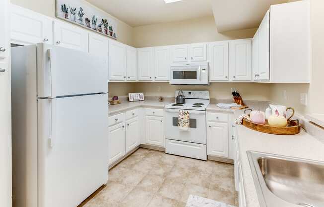 a white kitchen with white appliances and white cabinets