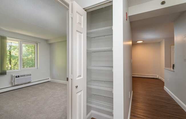 an empty living room with an open door to an empty closet