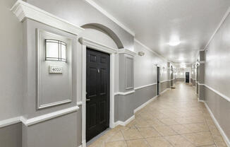 the hallway of a building with a lobby and a black door