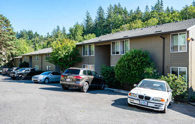 A white car is parked in a parking lot in front of a building.
