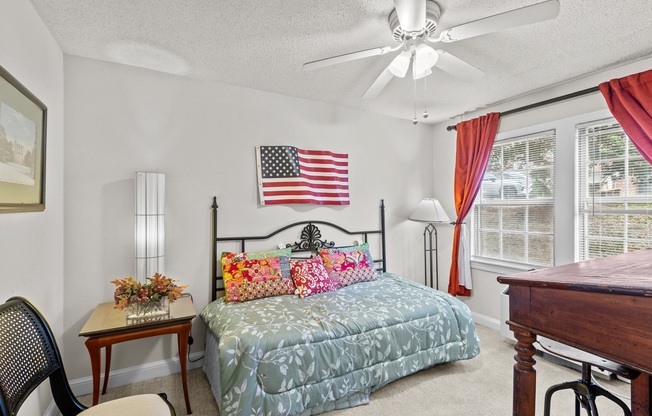 a bedroom with a bed and a large flag on the wall