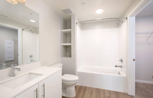 A white bathroom with a sink, toilet, and bathtub.