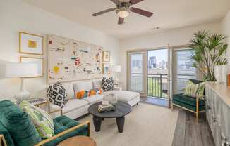 a living room with a ceiling fan and a door to a balcony