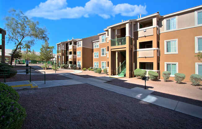 an exterior view of an apartment building with a sidewalk and courtyard