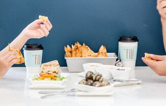 a table topped with plates of food and cups of coffee