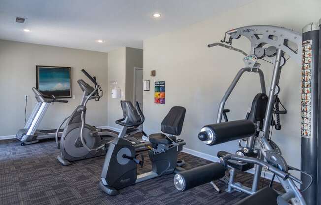 a gym with exercise machines and a tv