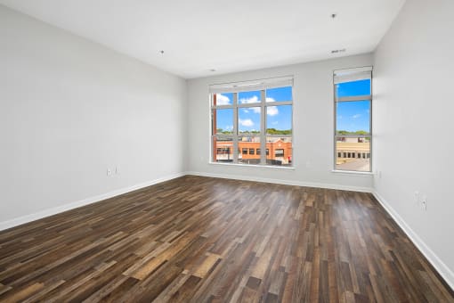 an empty living room with wood floors and a window