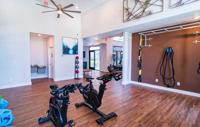 a home gym with exercise bikes and a ceiling fan