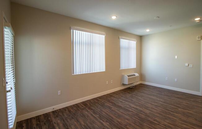 an room with two windows and a radiator at Loma Villas Apartments in San Bernardino, CA