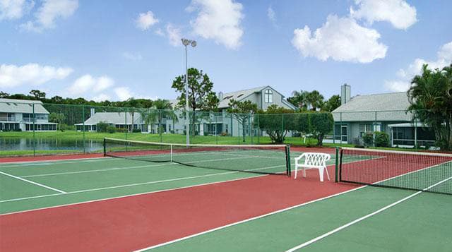 Setting up a game on the on-site tennis court will be an amenity you'll love at Lake in the Woods, Melbourne, FL, 32901