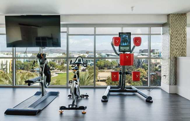 A home gym with a treadmill, exercise bike, and a weight lifting machine.