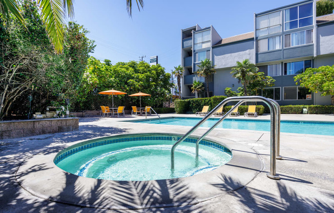 a hot tub in a pool with an apartment building in the background