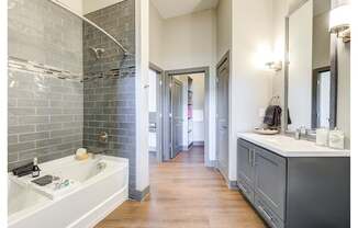 A bathroom with a white sink and a grey tiled wall.