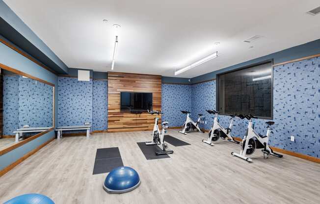 a gym with exercise equipment and a tv on the wall