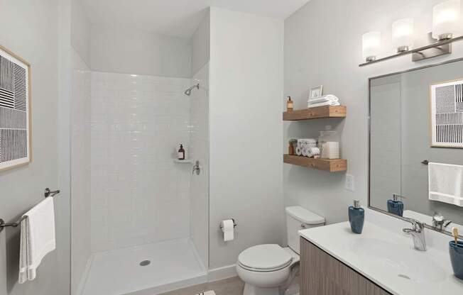 A bathroom with a toilet, sink, and shower.