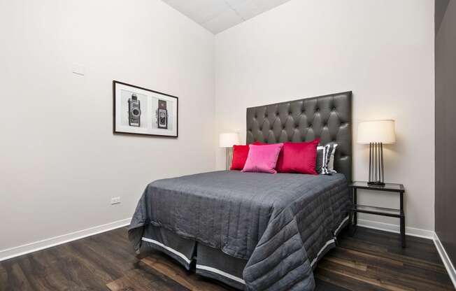 a bedroom with a bed with red pillows