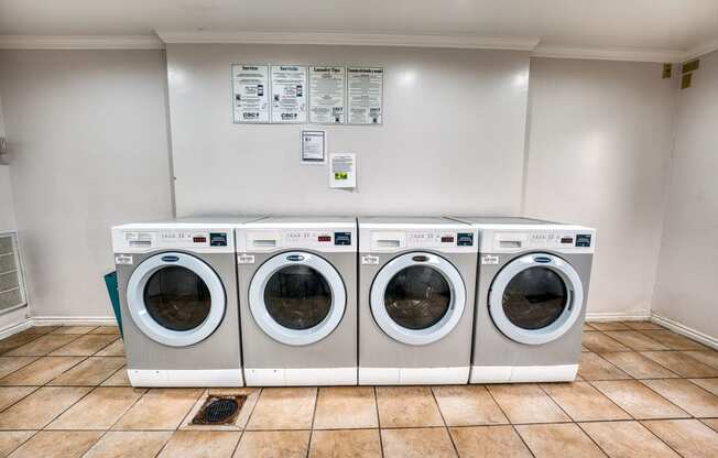 a laundry room with four washing machines in it