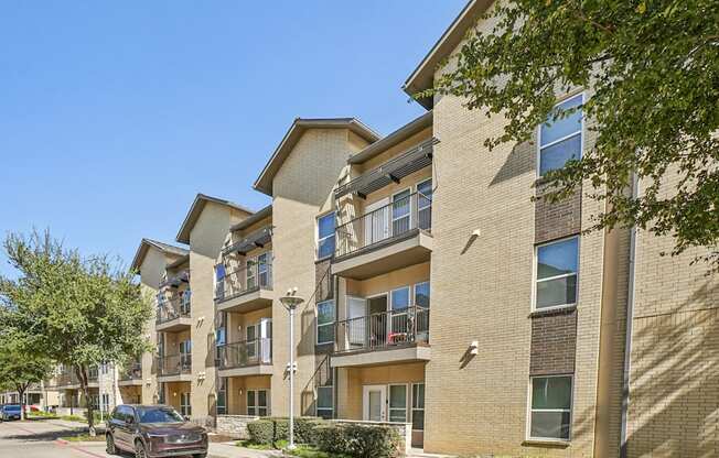 A black car is parked in a red marked spot in front of a building.
