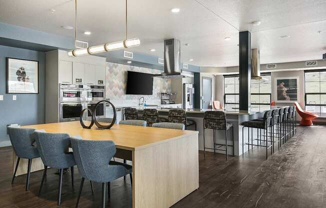 A modern kitchen with a large island and chairs.