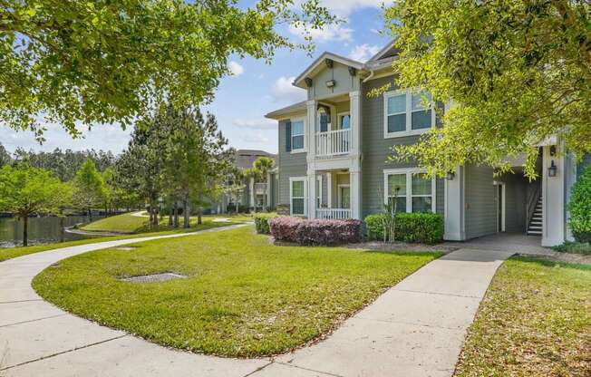 A residential building with a green lawn in front.