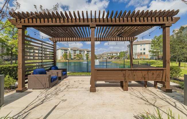 a patio with a pool and a wooden pergola