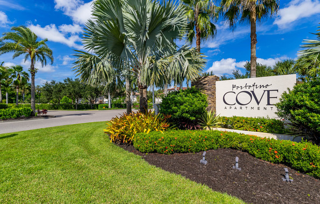 A sign for a penthouse apartment is in front of a well-manicured lawn.