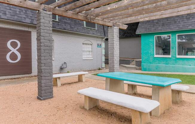 a picnic area with benches and a table in front of a building