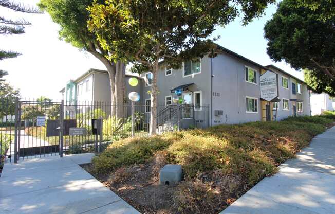 a building with a fence and a sidewalk in front of it