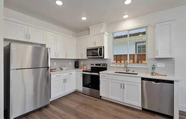 a kitchen with white cabinets and stainless steel appliances