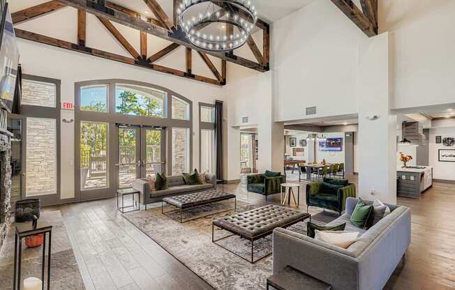 A large, open-concept living room with a high ceiling and wooden beams.